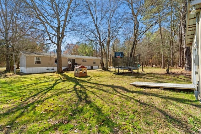 view of yard with a trampoline and a deck