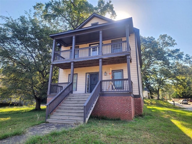 view of front of property with covered porch, a balcony, and a front lawn