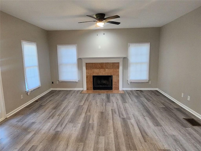 unfurnished living room with ceiling fan, light hardwood / wood-style floors, and a fireplace