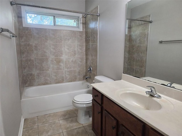 full bathroom with tile patterned floors, vanity, tiled shower / bath, and toilet