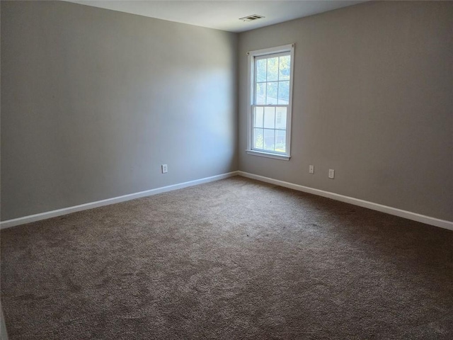 unfurnished room featuring dark carpet