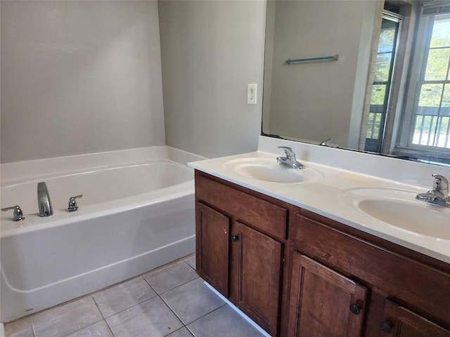 bathroom with tile patterned floors, a bathing tub, and vanity