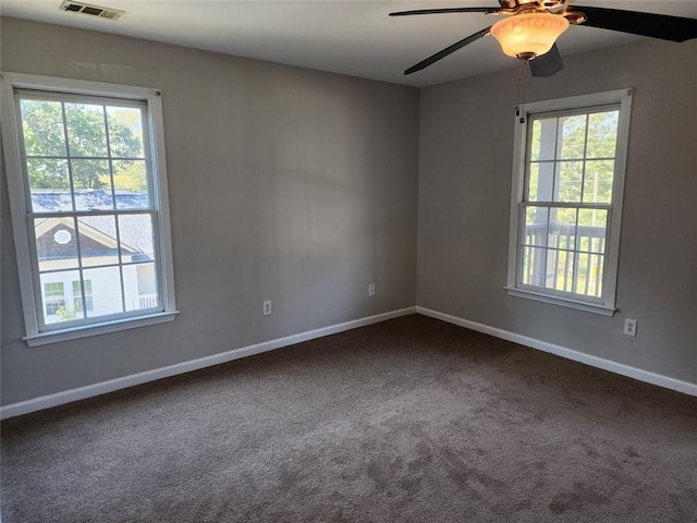 carpeted spare room featuring ceiling fan and a wealth of natural light