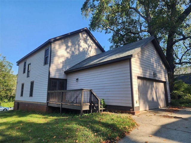 rear view of house with a garage, a yard, and a wooden deck