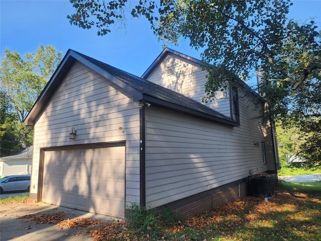 view of side of home with cooling unit and a garage