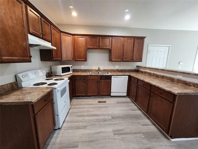 kitchen with kitchen peninsula, sink, light hardwood / wood-style floors, and white appliances