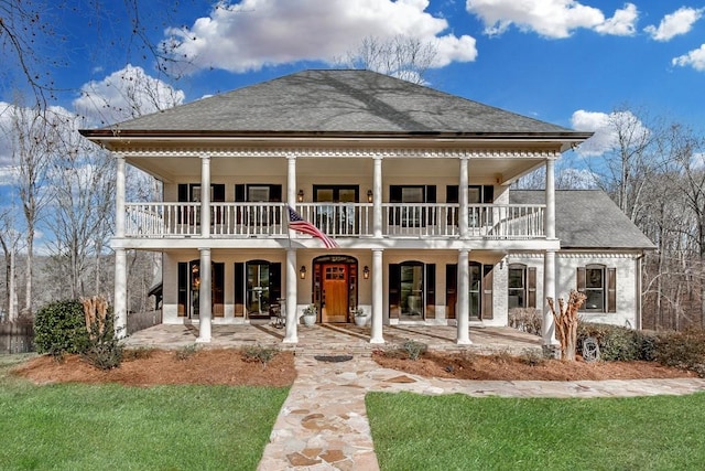 view of front of house with a patio area, a balcony, and a front yard