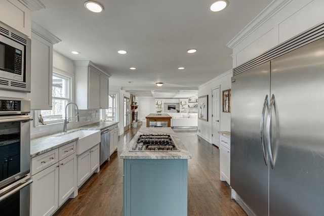 kitchen with white cabinets, built in appliances, and dark hardwood / wood-style floors