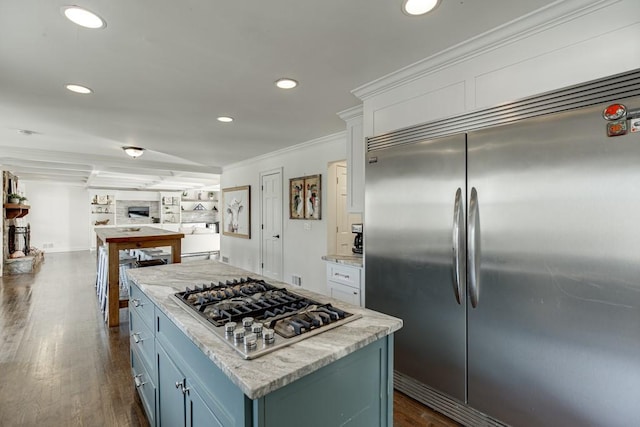 kitchen featuring dark hardwood / wood-style flooring, a kitchen island, ornamental molding, and appliances with stainless steel finishes