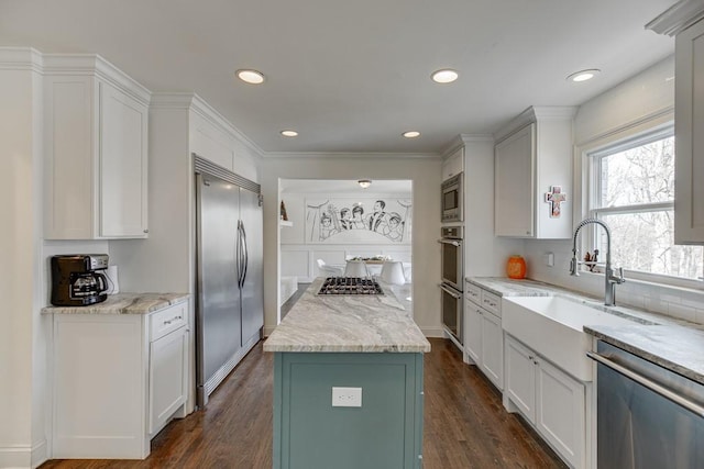 kitchen featuring a center island, sink, dark wood-type flooring, built in appliances, and white cabinets