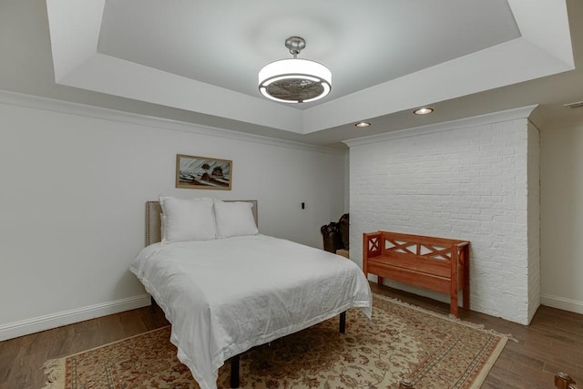 bedroom featuring a tray ceiling and dark wood-type flooring