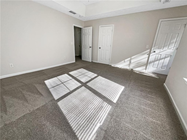 carpeted empty room featuring a tray ceiling