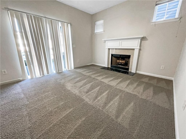 unfurnished living room with a high end fireplace and carpet flooring