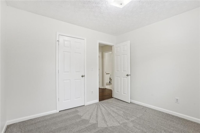 unfurnished bedroom with carpet floors and a textured ceiling