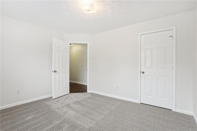 carpeted spare room with a textured ceiling