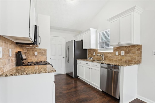 kitchen with light stone countertops, white cabinetry, appliances with stainless steel finishes, and sink