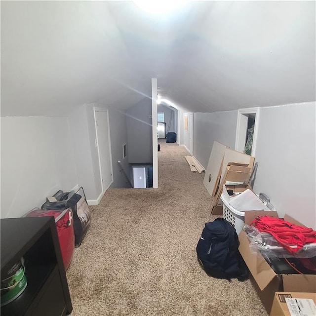 additional living space featuring light carpet and vaulted ceiling