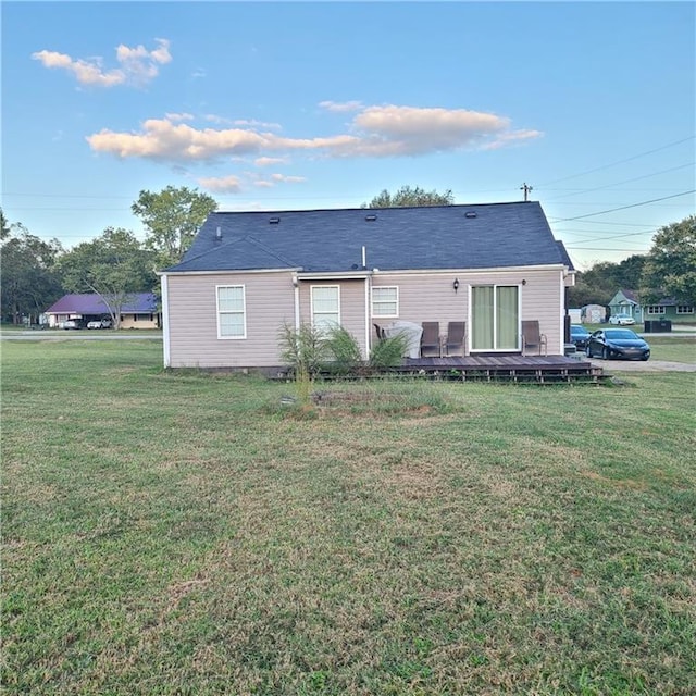 rear view of property featuring a lawn