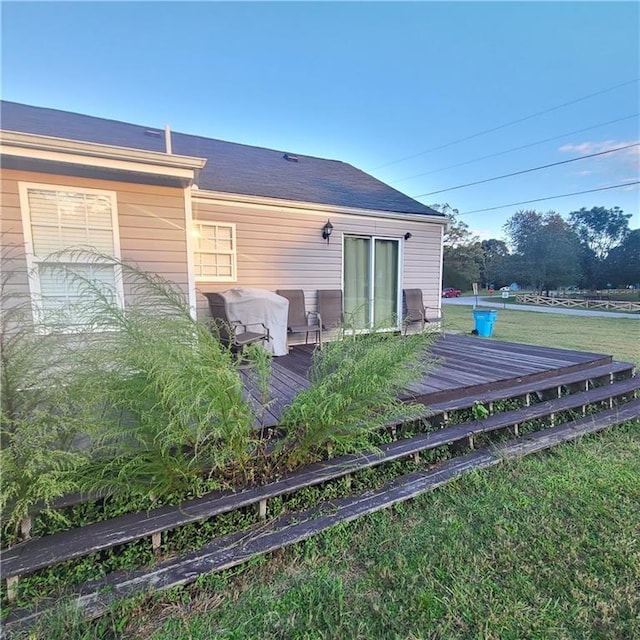 rear view of property with a yard and a wooden deck