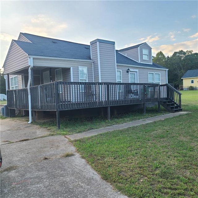 rear view of house with a yard and a deck