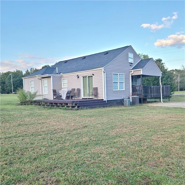 back of house with a wooden deck, central air condition unit, and a lawn