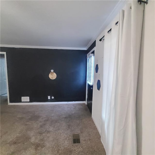 empty room with ornamental molding and carpet