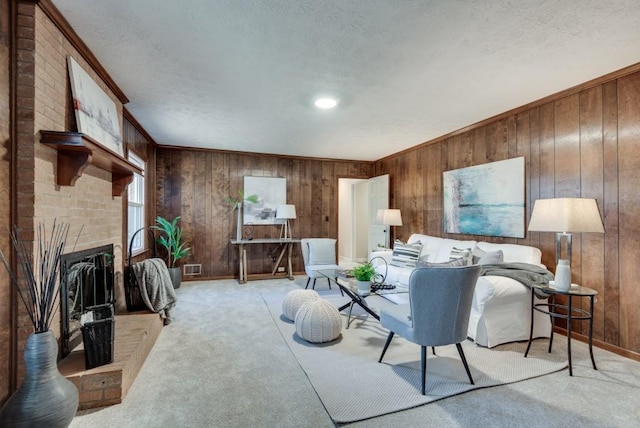 living room featuring wooden walls, light carpet, a textured ceiling, and a fireplace