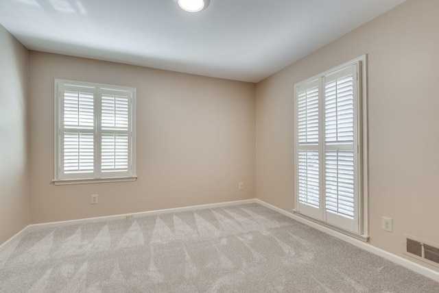 empty room featuring a healthy amount of sunlight and light colored carpet