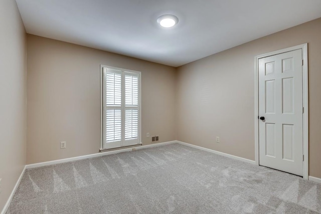 unfurnished room featuring light carpet