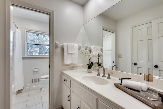 bathroom with vanity, tile patterned flooring, and toilet