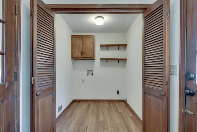 laundry area featuring cabinets, washer hookup, and light hardwood / wood-style floors