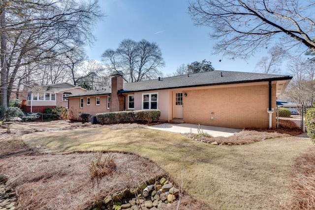 back of property featuring a lawn and a patio area