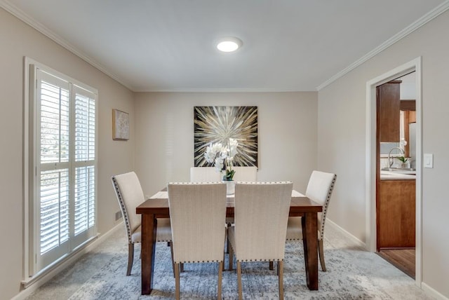 carpeted dining space featuring ornamental molding and sink