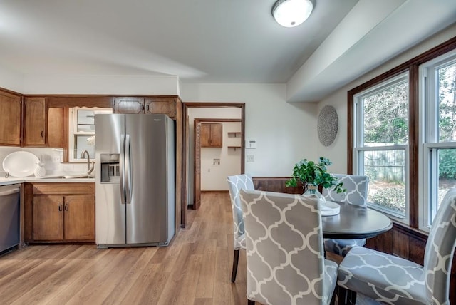 kitchen featuring tasteful backsplash, stainless steel appliances, light hardwood / wood-style floors, and sink