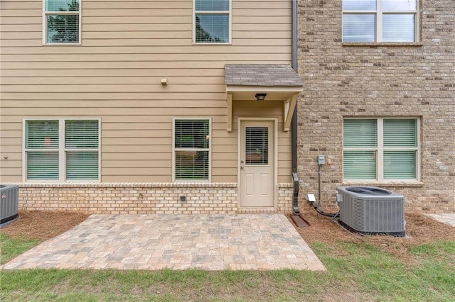 property entrance with central AC unit and a patio area