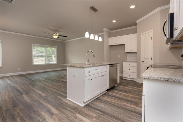 kitchen with pendant lighting, sink, stainless steel appliances, an island with sink, and white cabinets