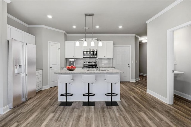 kitchen featuring an island with sink, appliances with stainless steel finishes, sink, and white cabinets