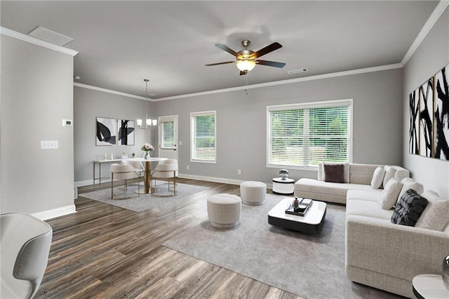 living room with crown molding, hardwood / wood-style flooring, and ceiling fan with notable chandelier