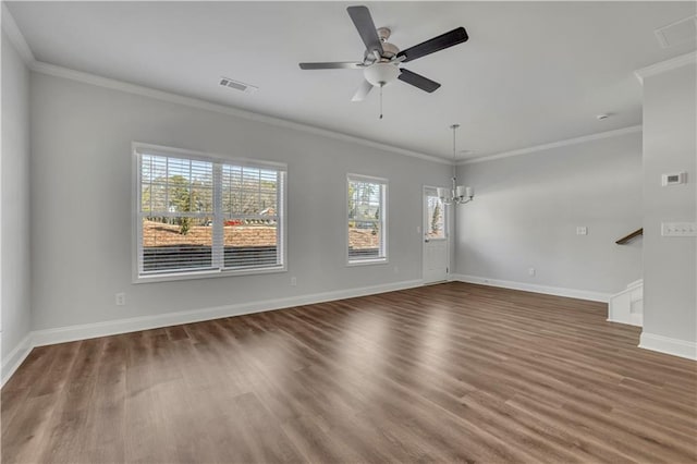 empty room featuring dark wood-type flooring, ornamental molding, and ceiling fan with notable chandelier