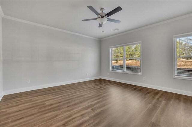 unfurnished room featuring dark wood-type flooring, ornamental molding, and ceiling fan