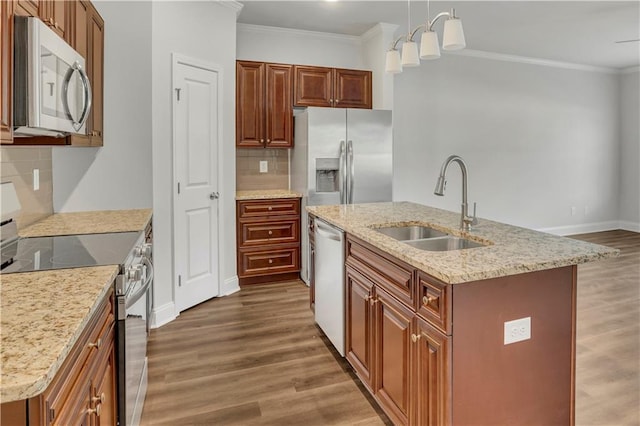 kitchen featuring appliances with stainless steel finishes, decorative light fixtures, an island with sink, sink, and dark hardwood / wood-style flooring