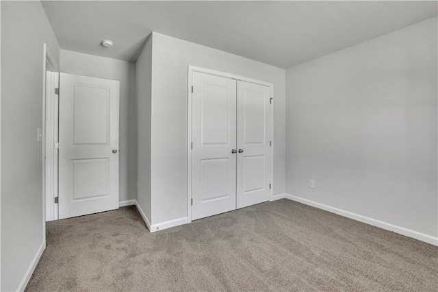 unfurnished bedroom with light carpet and a closet