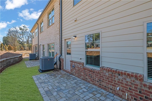 exterior space featuring central AC, a lawn, and a patio