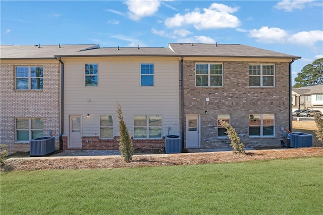 rear view of house with a yard and central AC