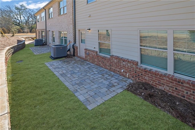 back of property with a patio, a lawn, and central air condition unit