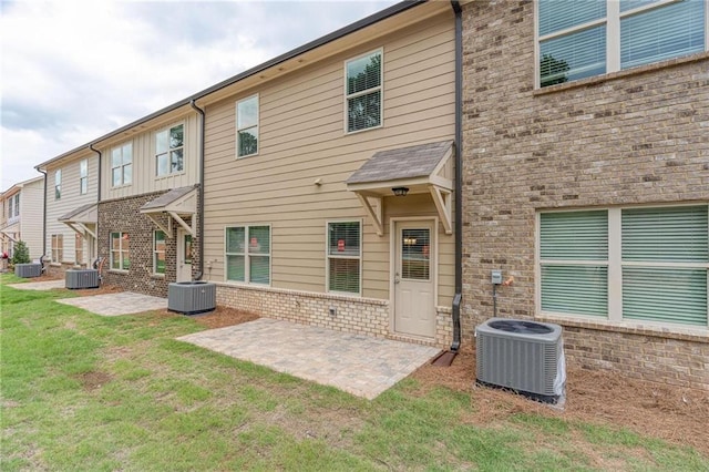 rear view of property featuring a patio, a yard, and central air condition unit