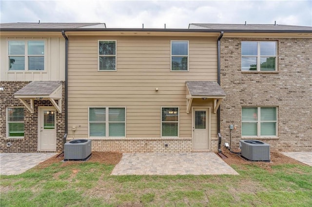 back of property featuring a yard, cooling unit, and a patio area