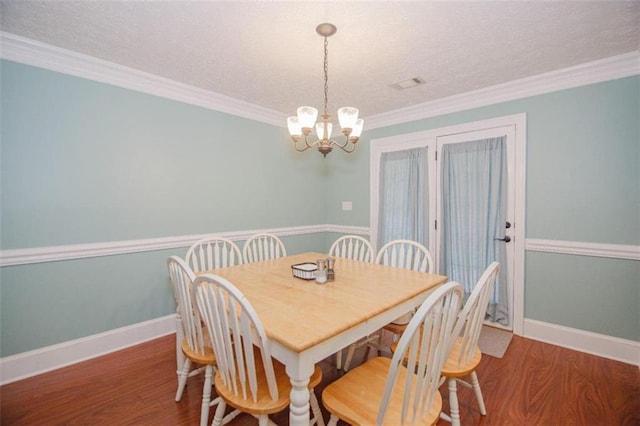 dining area featuring crown molding, a chandelier, hardwood / wood-style floors, and a textured ceiling