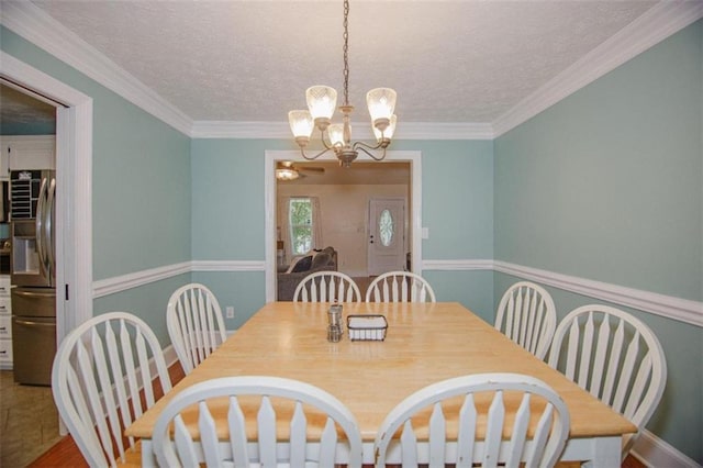 dining room featuring crown molding, a textured ceiling, and a chandelier