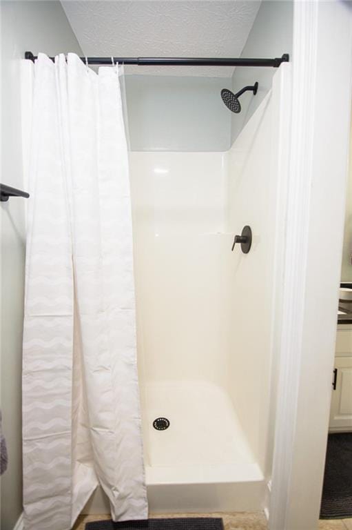 bathroom with a shower with curtain and a textured ceiling